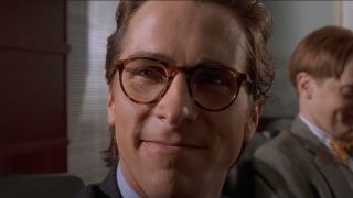 Christian Bale smiles while wearing his Oliver Peoples glasses in American Psycho.